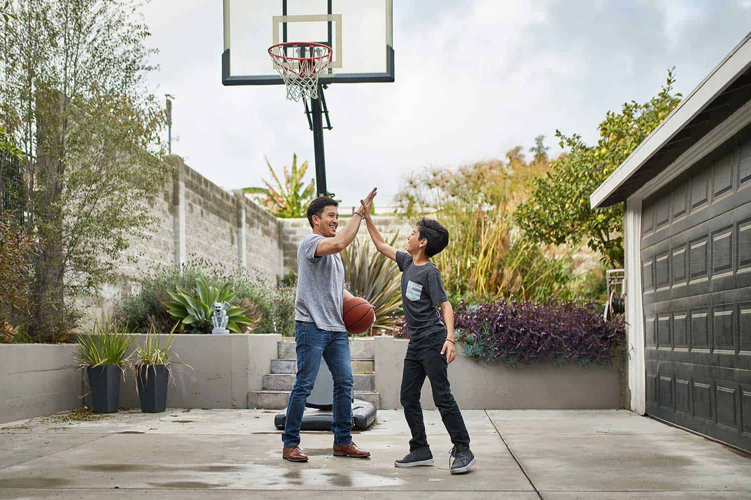 Father and son giving high-five while playing basketball