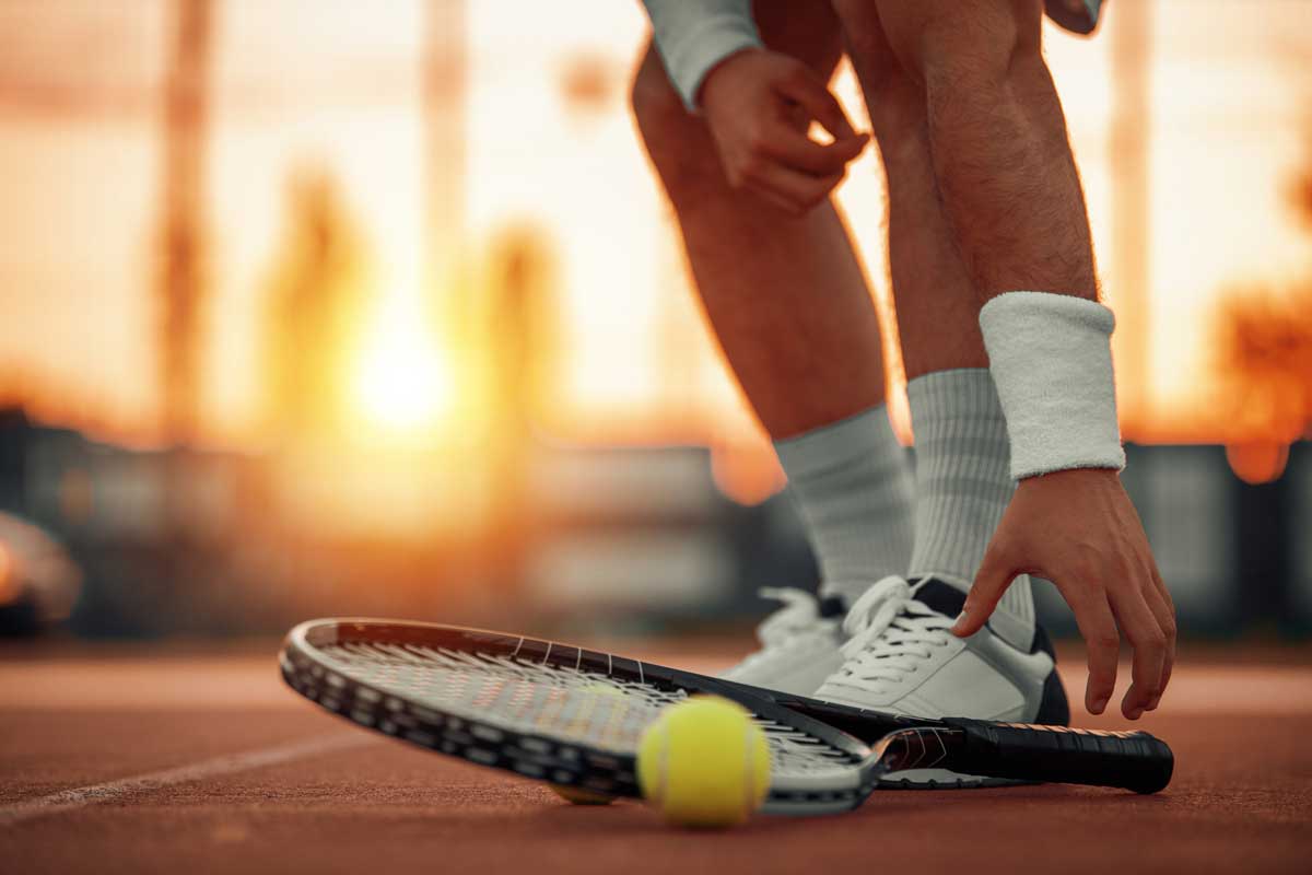 Man on tennis court.He is holding racket in hands with non-slip shoes, Are Tennis Shoes Non-slip?