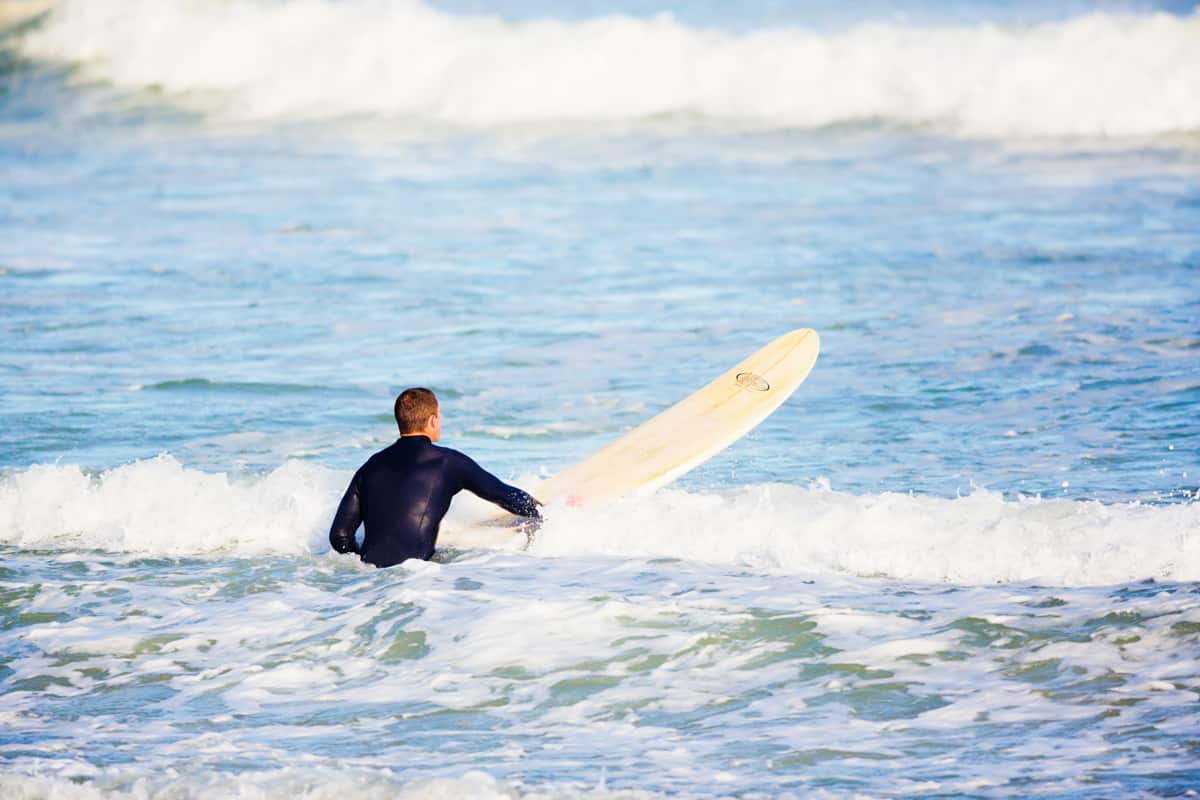 A young surfer riding on his surfboard waiting for bigger waves to come