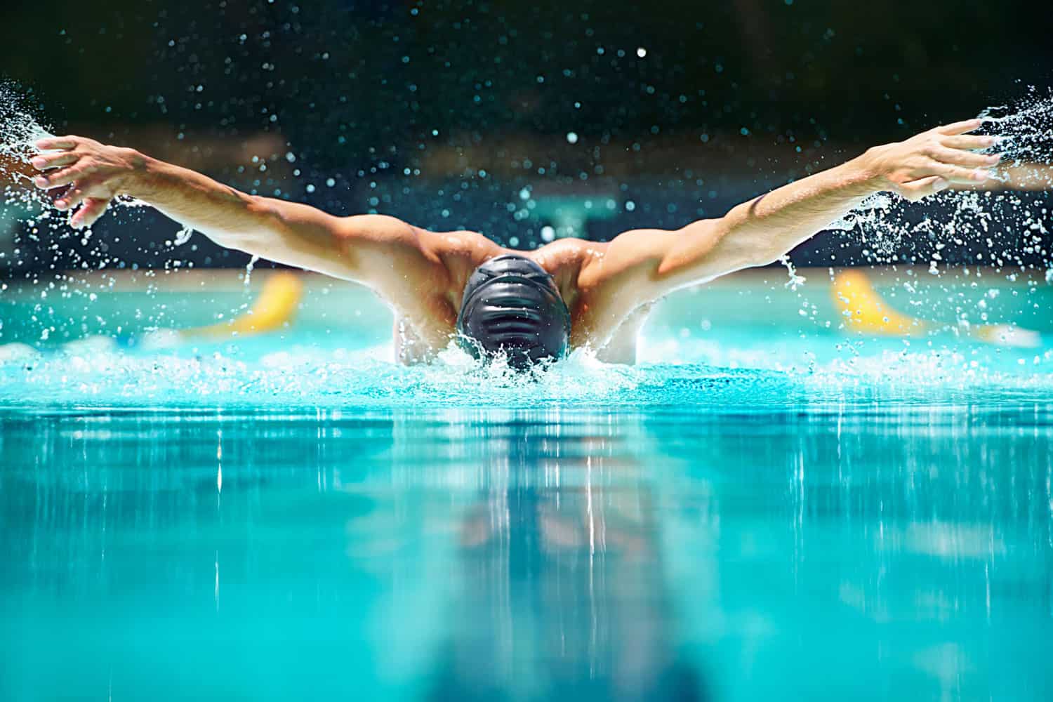 A male swimmer doing butterfly stroke toward the camera
