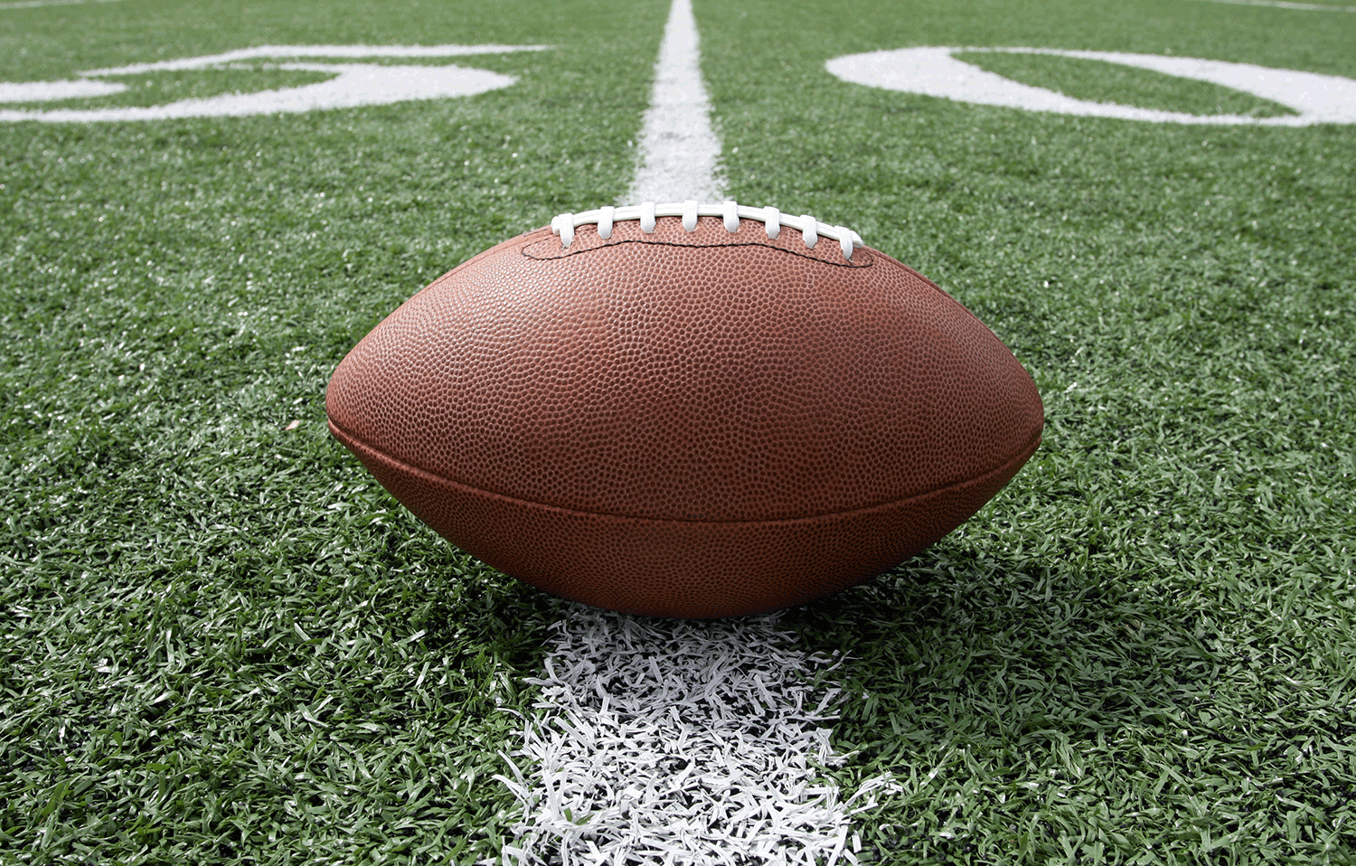 Ground level view of a football on the fifty yard line