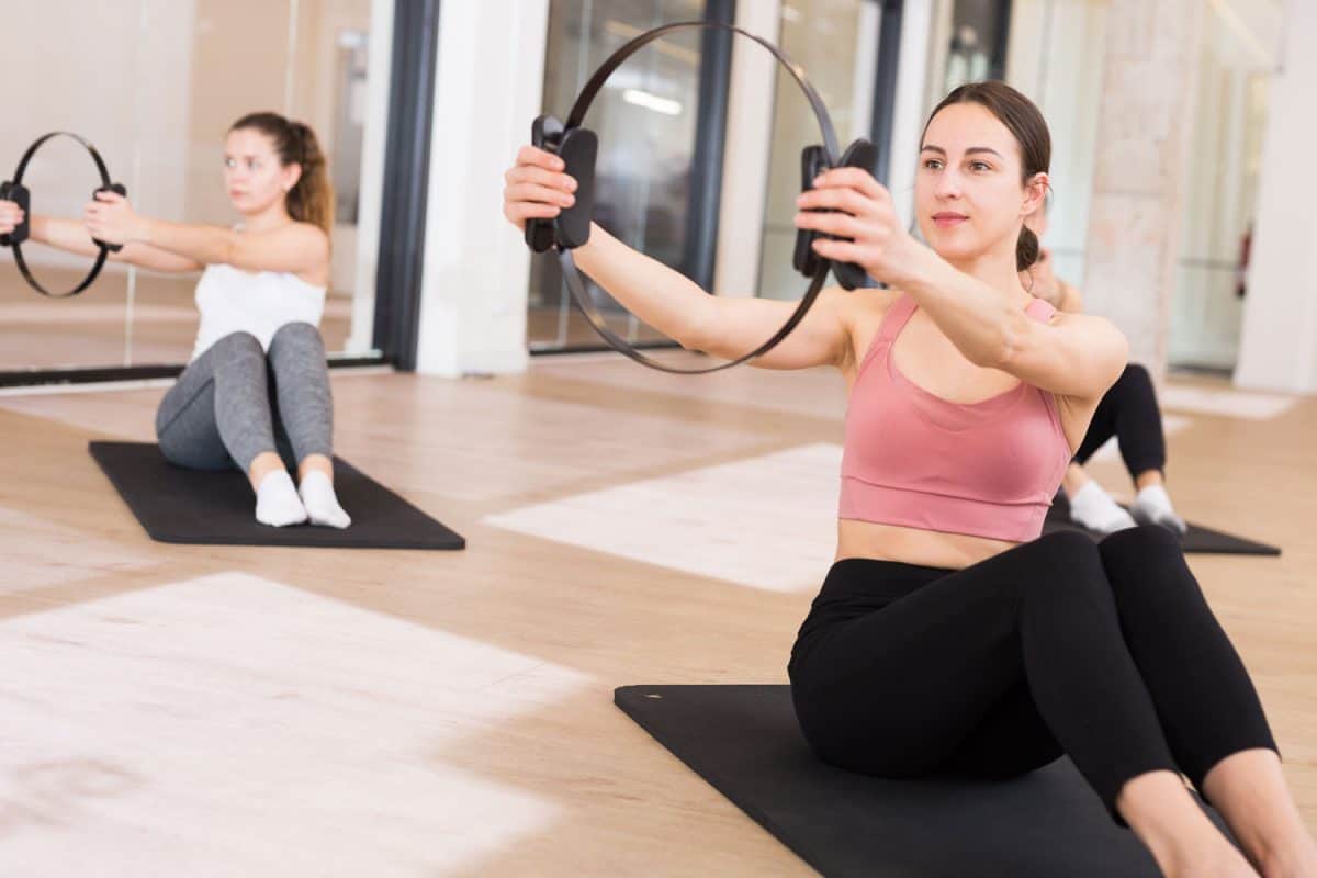 Two women holding Pilates rings on their workout