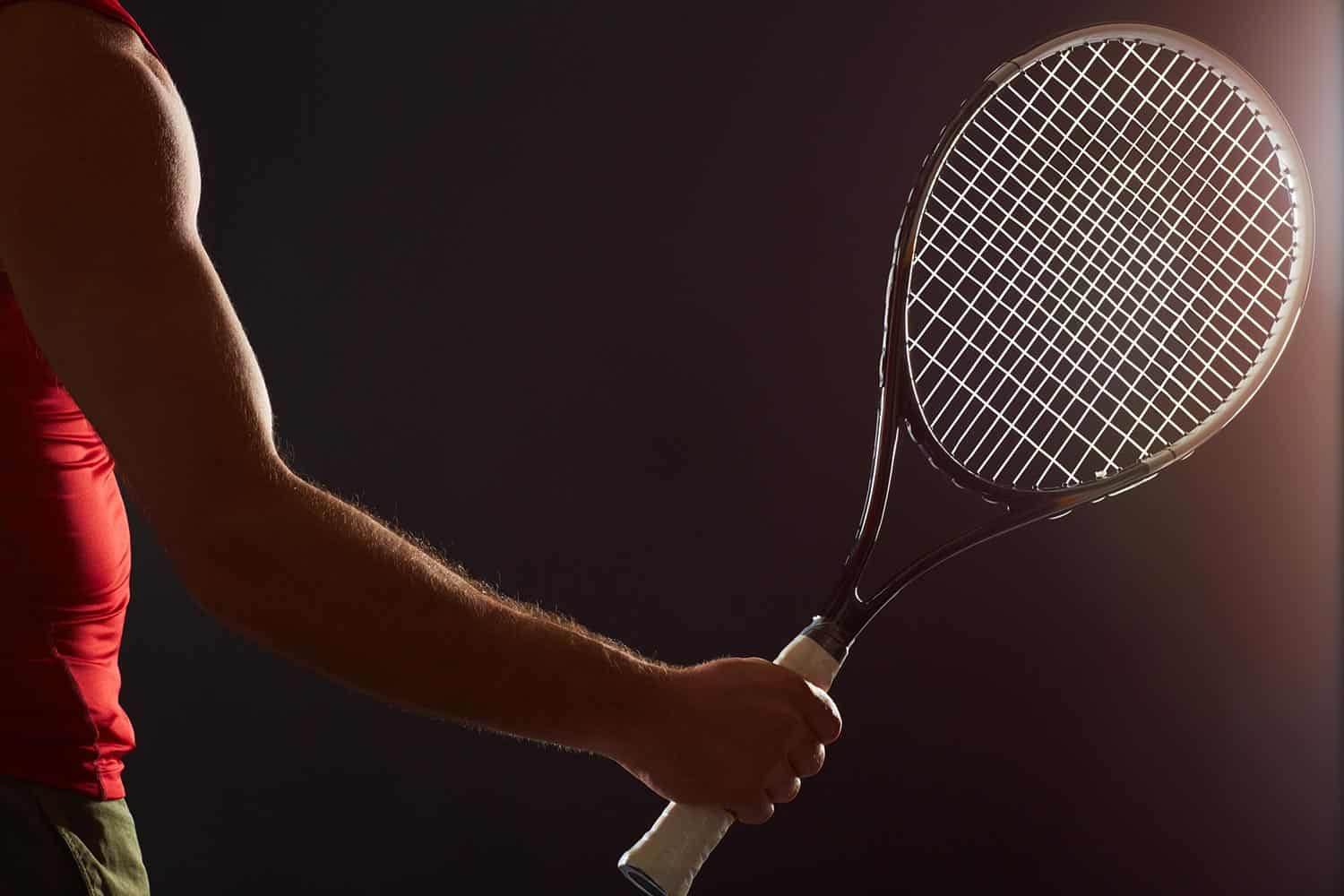 Tennis player's arm and hand holding a tennis racket