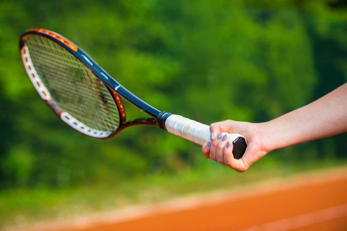 A woman holding a tennis racket tightly