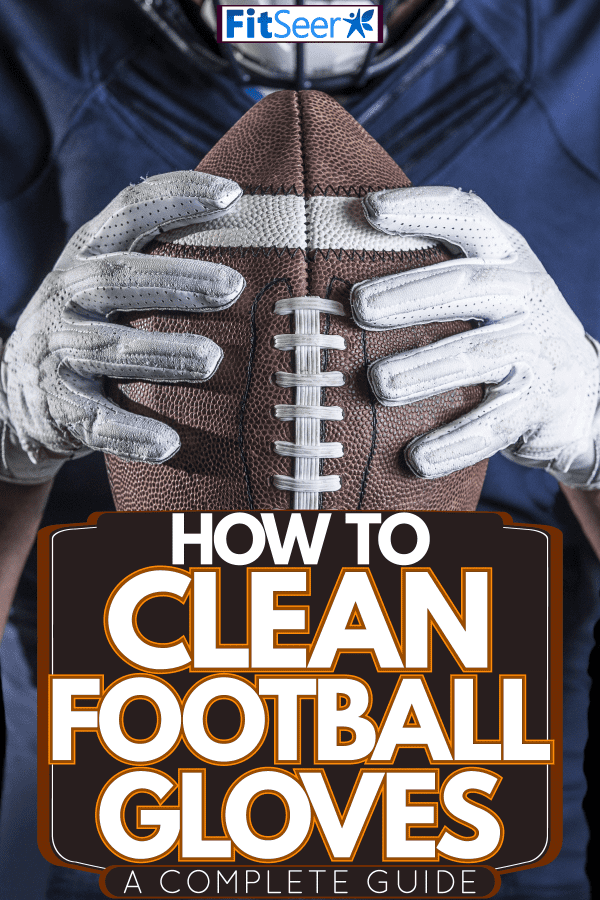 A football player wearing white football gloves and holding a football tightly, How To Clean Football Gloves [A Complete Guide]