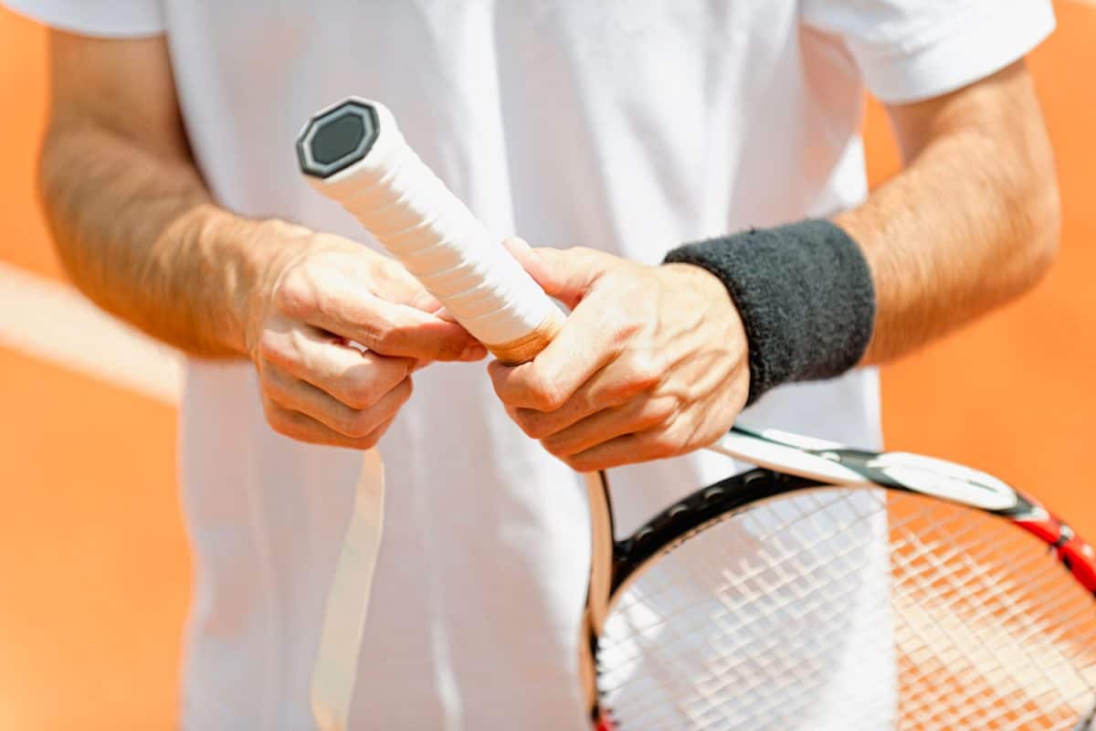 Tennis player wrapping tape around the tennis grip