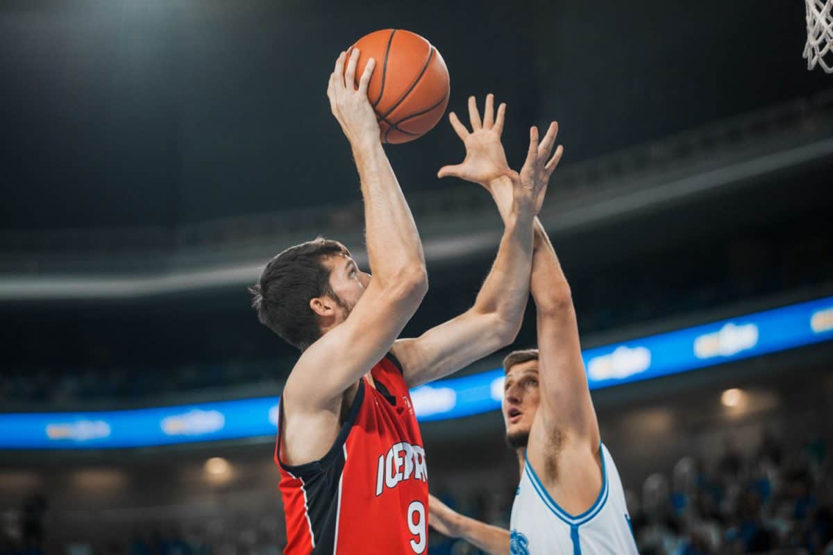 Two basketball players taking the ball