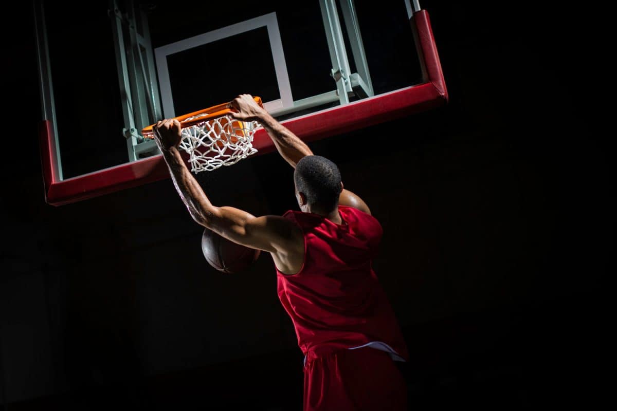 A tall basketball player dunking