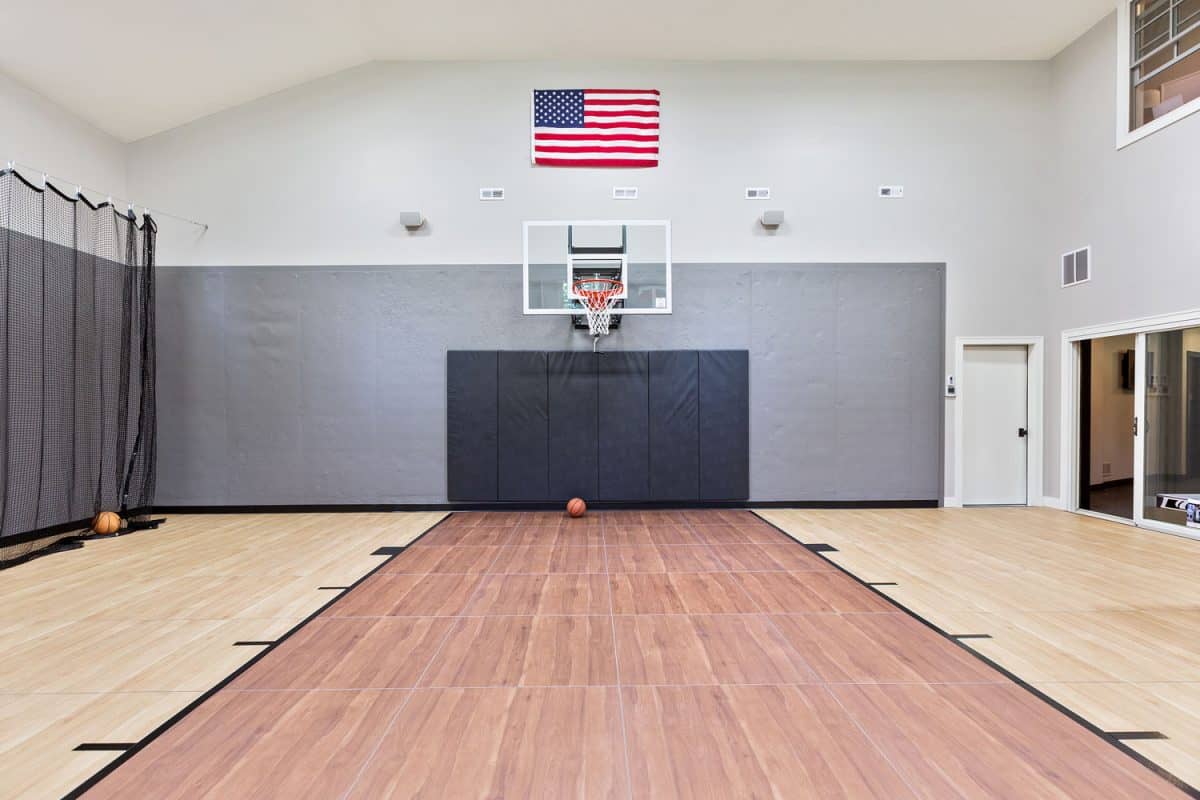 An indoor basketball with hardwood flooring and the American Flag on the wall