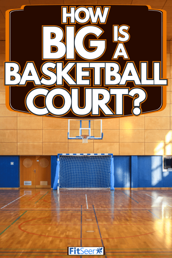 A huge indoor basketball court with hardwood flooring and windows for lighting, How Big Is A Basketball Court?