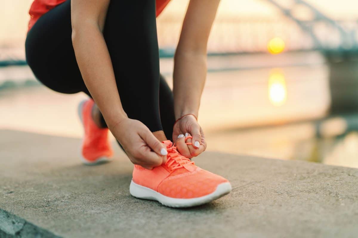 Woman tying her running shoes on her running session