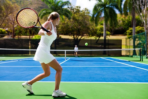 two people playing tennis in a tropical settingview images from the same series