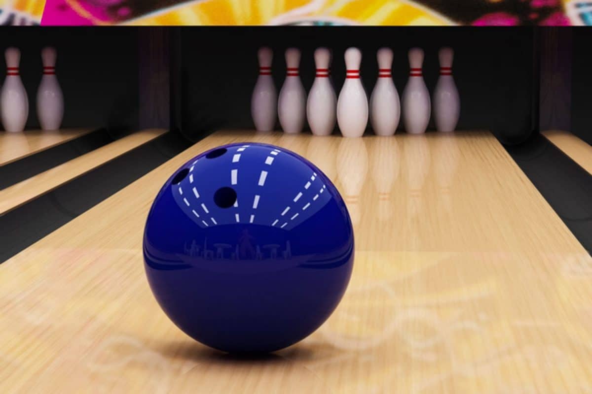 A blue bowling ball left on the alley