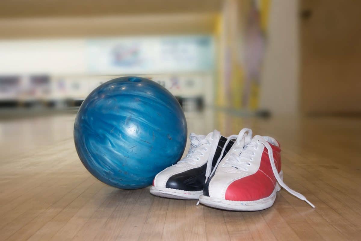 Bowling ball and bowling shoes placed next to each other