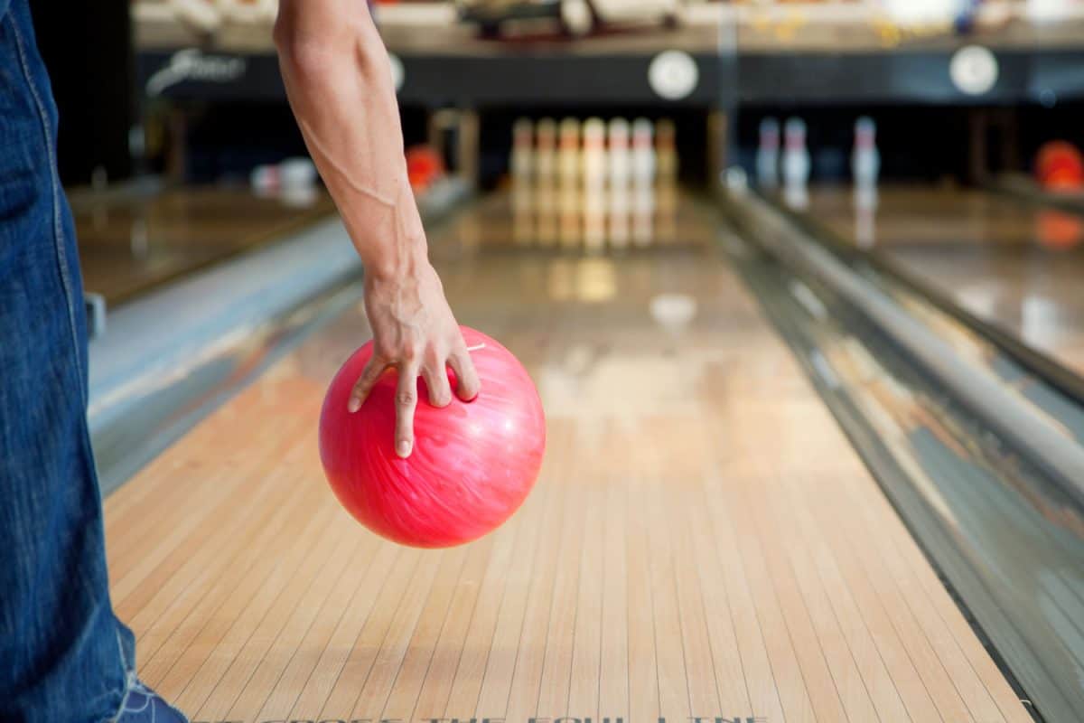 Bowling player tossing the pink bowling ball