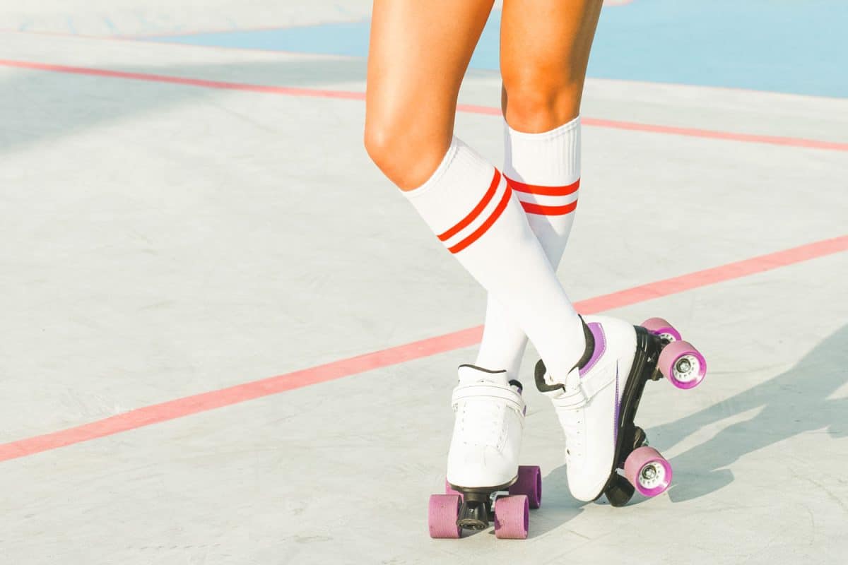 Woman wearing knee high socks and showing her white roller skates