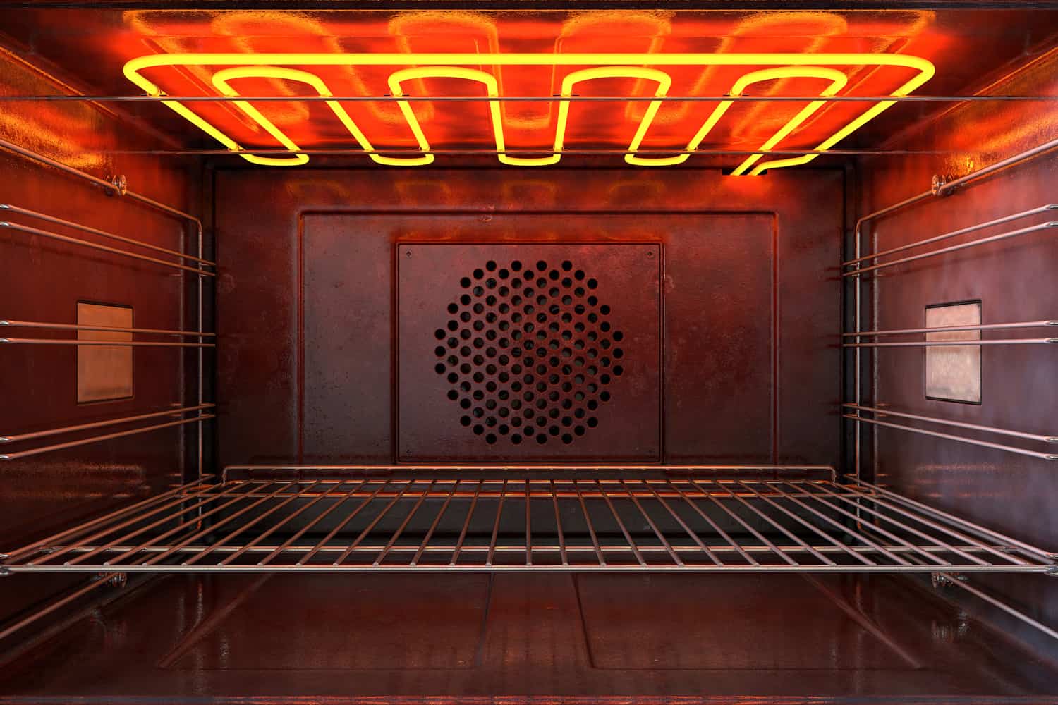 An upclose view through the front of the inside of an empty hot operational household oven with a glowing element and metal rack 