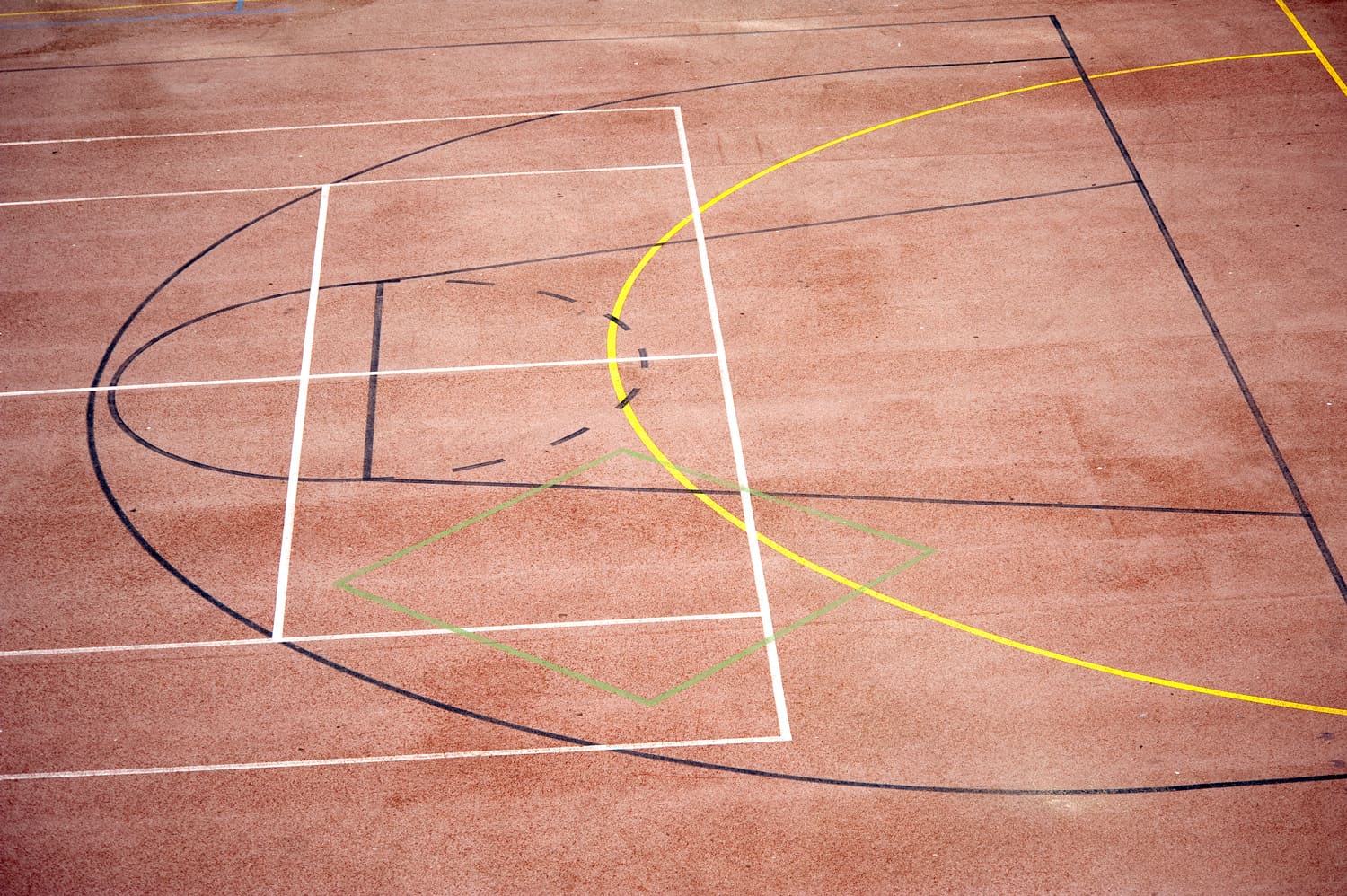 Lines on an outdoor basketball court.