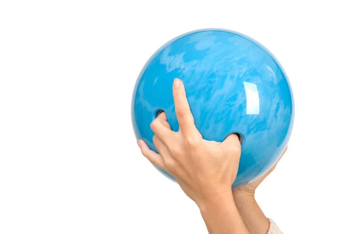 Woman properly holding a blue bowling ball