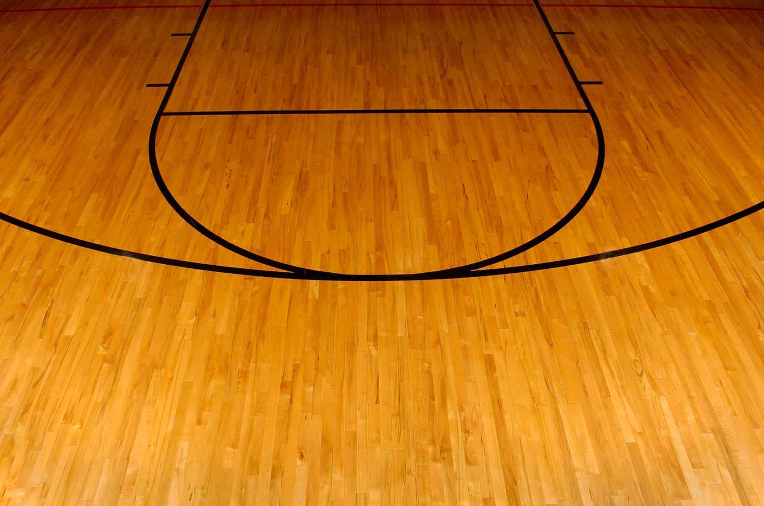 Wooden basketball floor with the foul and three point line.